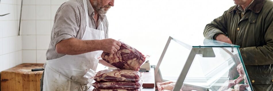 AI-generated editorial illustration of a butcher lifting a vacuum-packed joint of marbled beef from a stack of plain packs while a farmer watches across the counter